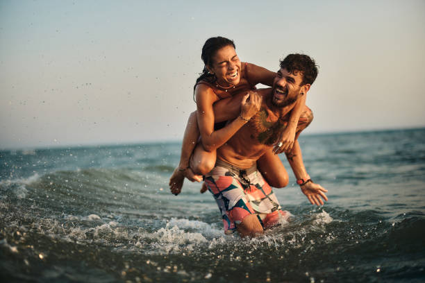 istock Cheerful couple having fun while piggybacking at sea. 2154960729