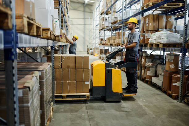 istock Warehouse worker working with pallet jack in a storage room. 2154960983