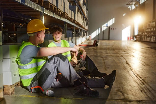 istock Happy manual workers talking on a break in distribution warehouse. 2154961930