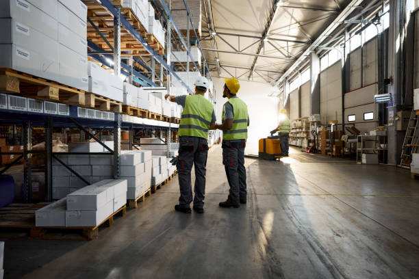 istock Back view of manual workers working with packages in distribution warehouse. 2154962071