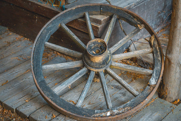 a very old, historic, antique horse cart wheel like from a western movie horse cart wheel lying on a wooden floor in the countryside covered wagon horse cart snow winter stock pictures, royalty-free photos & images