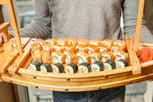 istock Person Holding Tray of Sushi Rolls 2154964010