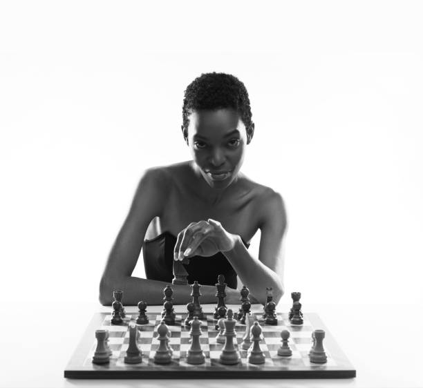 istock Black woman playing chess and holding a piece 2154966774