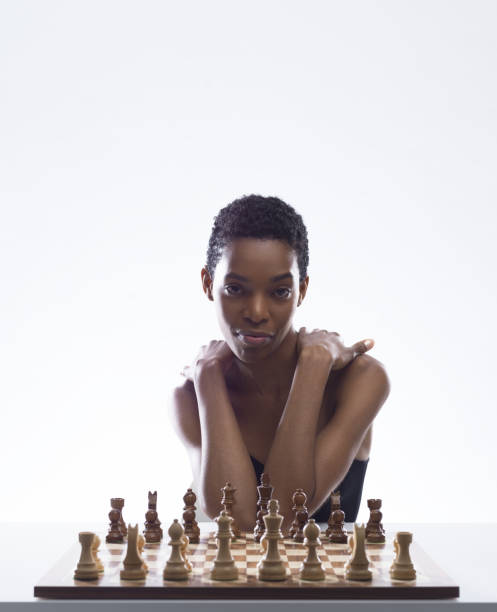 istock Beautiful woman playing chess and looking at camera 2154966828