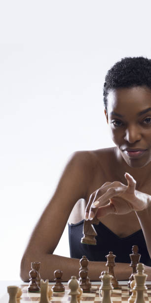 istock Black woman playing chess and holding a piece 2154967336