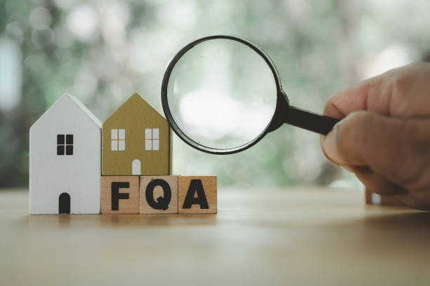 istock Man hand uses magnifying glass to find answer FAQ about home. Question and answer about housing problems 2154967379