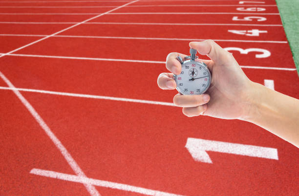 Human hand holding stopwatch on the running track