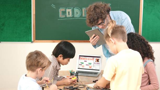 istock Group of diverse student working together while teacher hold tablet. Pedagogy. 2154967903