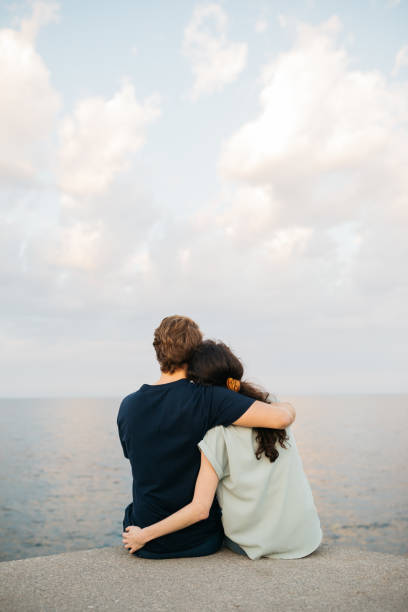 istock Young couple hanging out next to the sea. 2154968678
