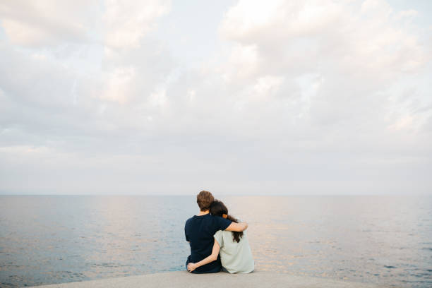 istock Young couple hanging out next to the sea. 2154968689