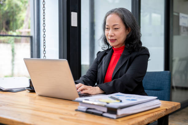 istock A confident and professional mature Asian businesswoman working on her computer at her desk. 2154969607