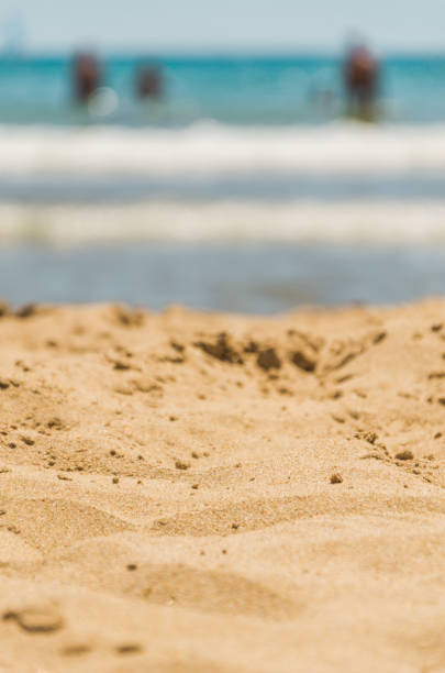istock Beach sand with sea waves and bathers in the distant. 2154970350