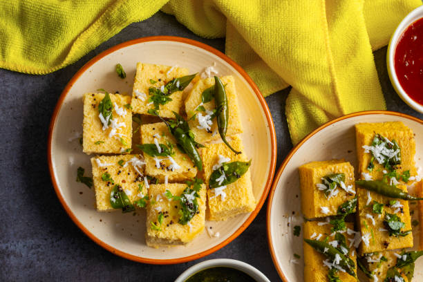 famous gujrati snack dhokla made with gram flour and sugar syrup decorated with mint and tomato chutney. - gujrati fotografías e imágenes de stock