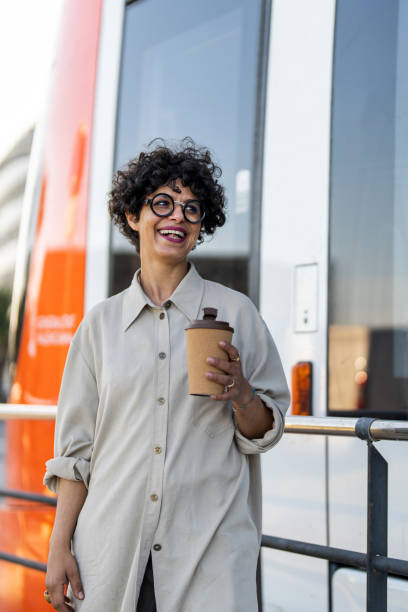 istock Smiling Woman with Takeaway Coffee in Urban Setting 2154971640