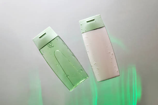 istock Shampoo and hair conditioner in water on a white background with colored light. 2154971692