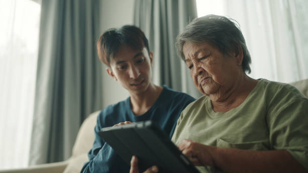 istock Elderly and teenager using digital tablet together. 2154972803