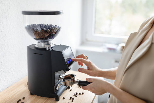 Woman barista make grinding coffee beans with machine