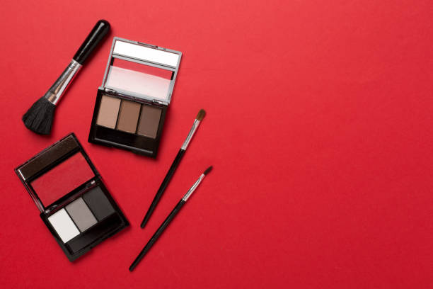 Eye shadows with brushes on color background, top view