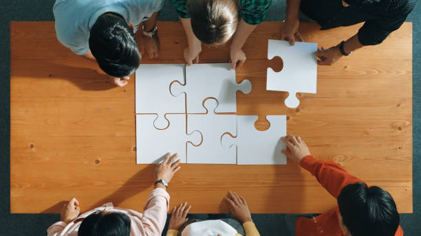 istock Top down view of business people assemble jigsaw puzzle on table. Convocation. 2154975775