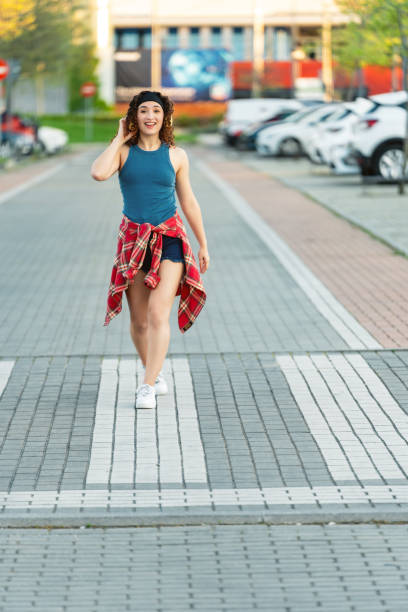 istock Curly-haired woman walking joyfully in urban setting. 2154975932
