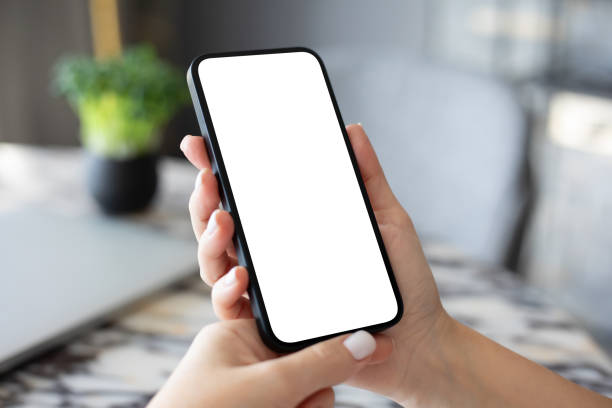 istock Female hand hold phone with isolated screen background table office 2154976846