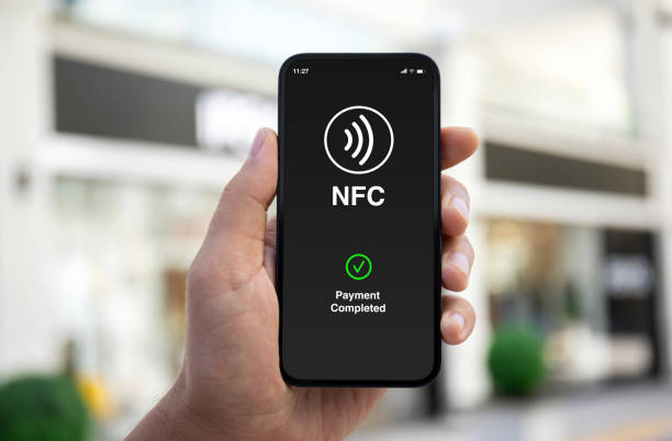 istock Male hand phone pay wireless technology nfc via pos terminal 2154977029