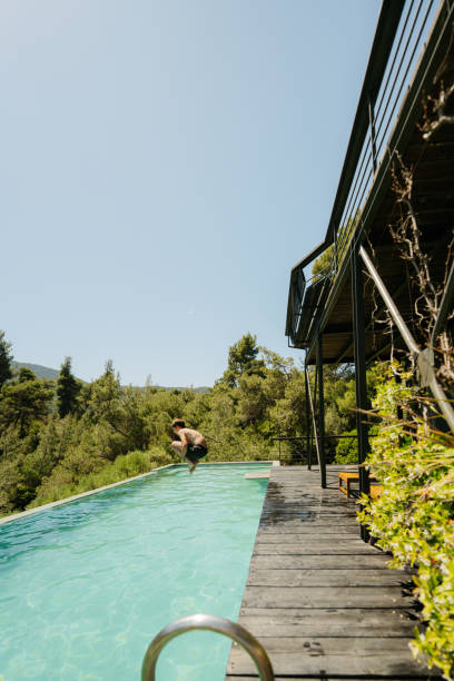 istock Young boy jumps into the swimming pool 2154979397