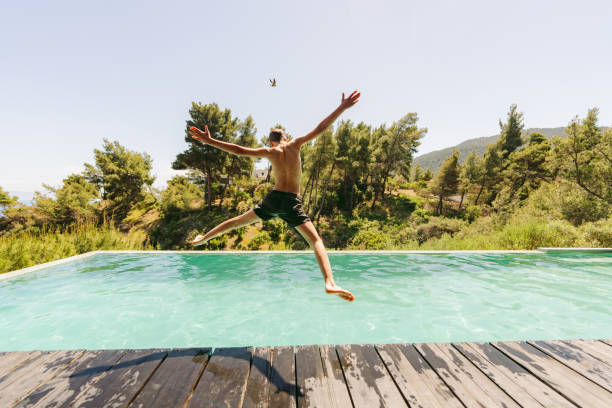istock Young boy jumps into the swimming pool 2154979417