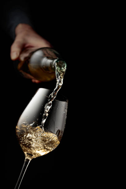istock Pouring white wine in a glass goblet. 2154979533