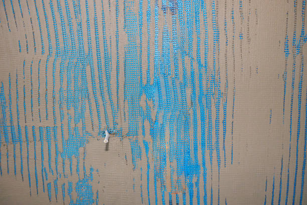 A top-down abstract background of an old, dirty, and cracked white tile wall. Perfect for grunge, decay, or abstract design backgrounds.
