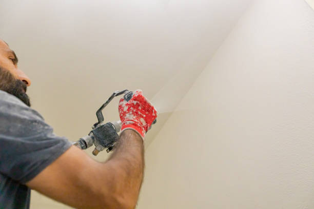 istock Worker is applying skim coating material to the wall before painting 2154982485