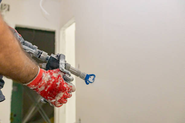 istock Worker is applying skim coating material to the wall before painting 2154982523