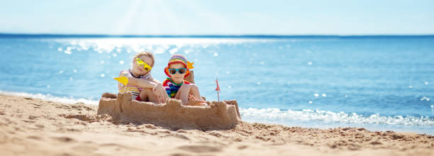istock Boy and girl building on the beach sandcastle. 2154983635