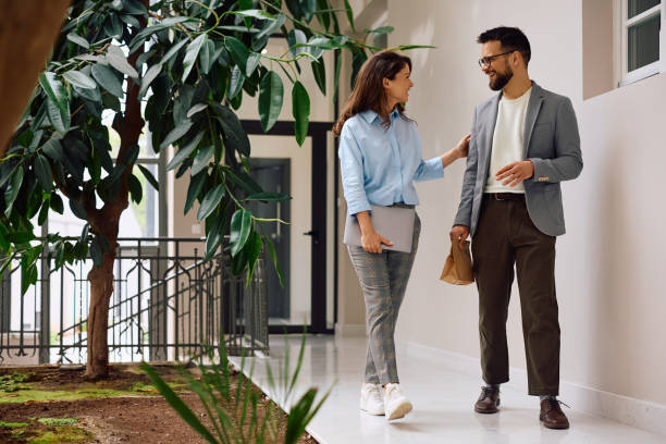 istock Two happy coworkers talking in office building hallway. 2154984350