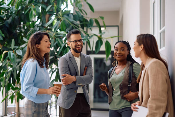 istock Cheerful business colleagues talking in office hallway. 2154984367