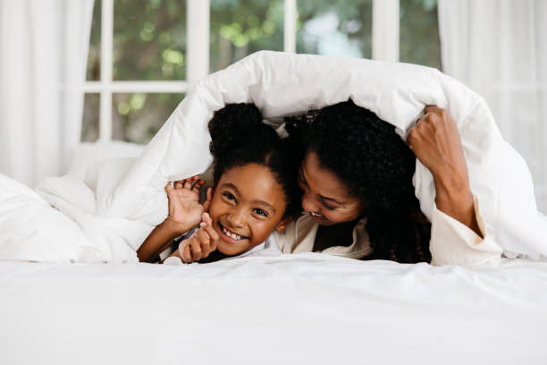 istock Joyful mother and daughter playing under blanket 2154986487