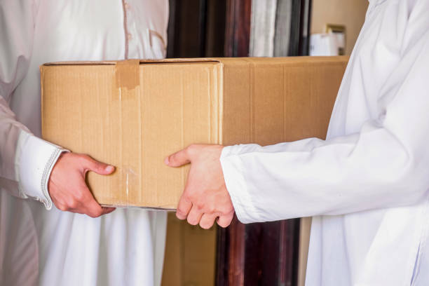 Arabic man holding box of cartoon