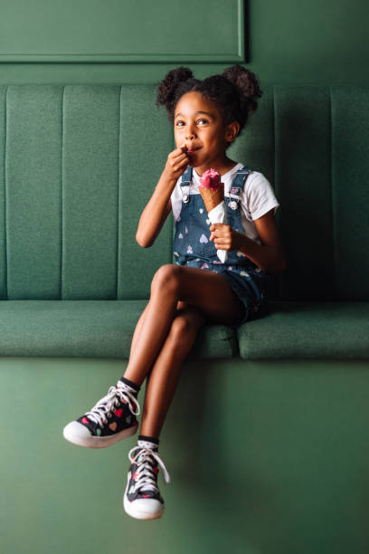 istock Happy young girl enjoying a raspberry ice cream cone 2154986679
