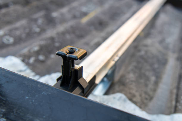 Aluminum construction frame with clamps for the installation of a number of new solar panels on the roof of a family house.