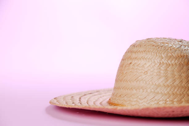 Peach colored sunhat and sunglasses on a wicker side table outdoors and Autumn leaves, Indiana, USA