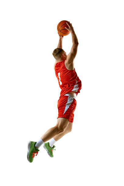 istock Basketball player, dressed in red uniform, performing perfect slam dunk against white studio background. 2154988872