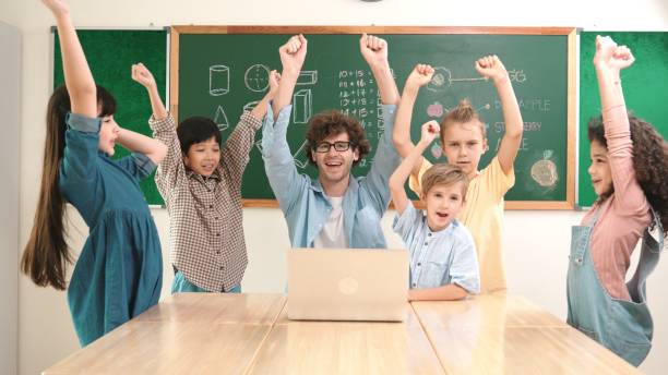 istock Teacher and student looking at laptop while celebrate success project. Pedagogy. 2154988940