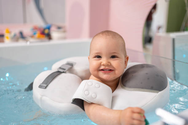 Close-up shot of baby smiling enjoying the water stock photo