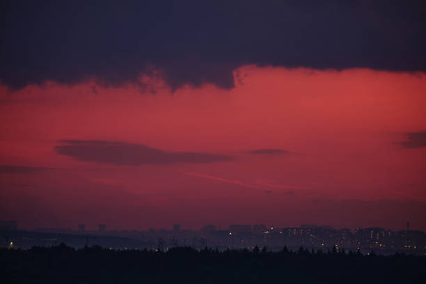 Nature's twilight show painted the evening skyline with deep reds and soft oranges above the city's roofs.