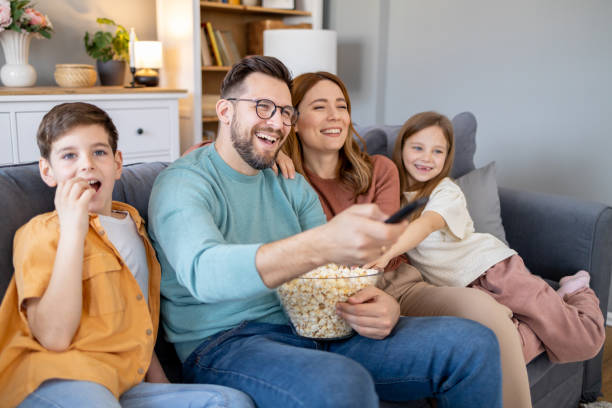istock Family sharing a laugh while watching TV at home 2154998524
