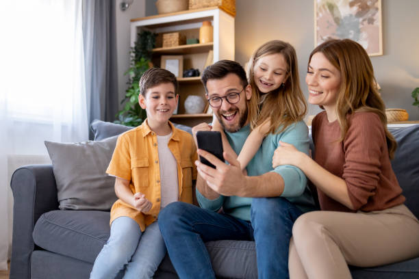 istock Happy family interacting with a mobile device 2154998531