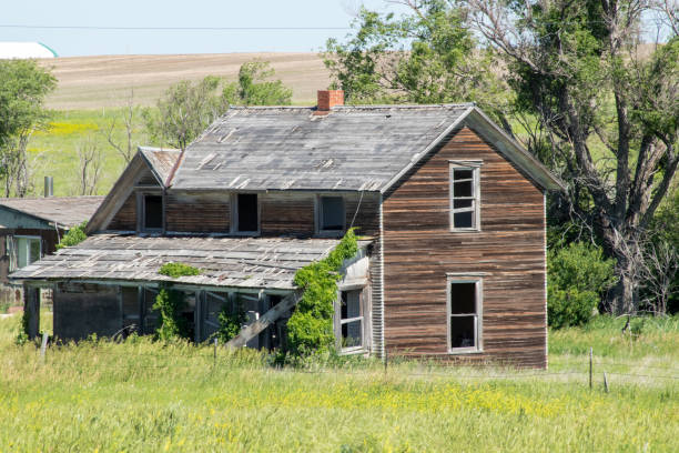 istock A old abandon farm house with a grass field 2155000282