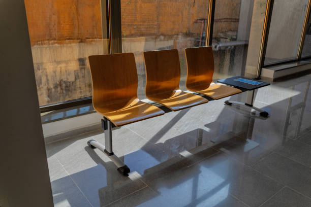 Sunlight rays in a waiting room of a health center. It is a very bright day in February. Bench seats and door are painted red.