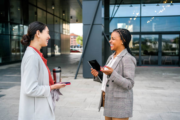 istock Two diverse female coworkers talking outdoors 2155002808