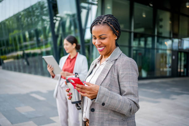 istock Businesswoman using phone in front of an office building 2155002914